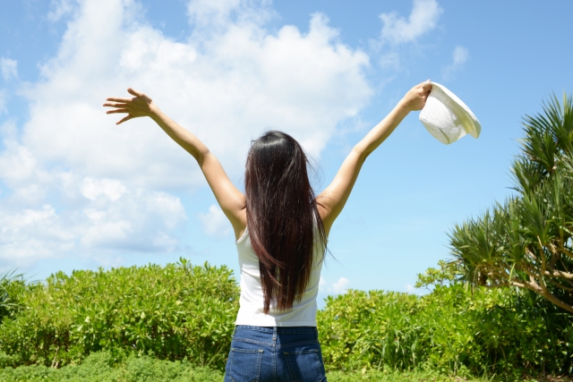 空に向かって手を広げる女性